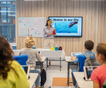 Teacher presenting a water-themed lesson to students in a classroom.