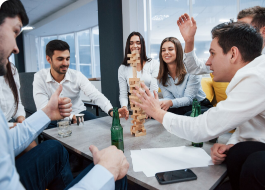 Office workers participating in a Jenga game, highlighting teamwork and interaction in a professional environment.