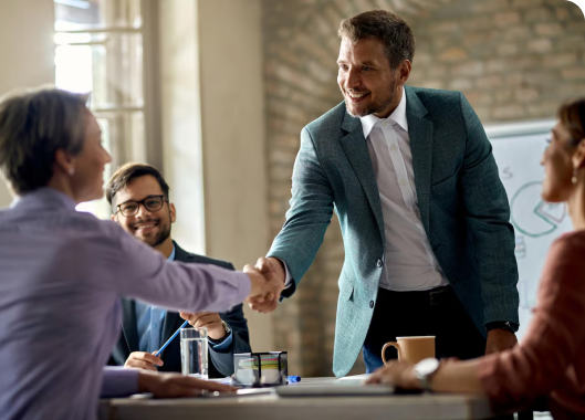 A handshake between two men at a meeting, illustrating mutual respect and the beginning of a professional relationship.