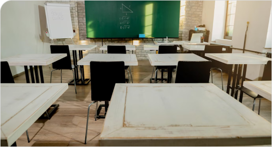 A classroom featuring white tables and black chalkboards, designed for scalable learning environments.