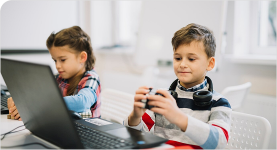 Two children focused on a laptop, enjoying video games together, highlighting the role of technology in modern playtime.