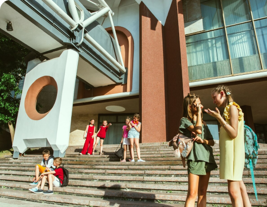 A diverse group of young individuals stands confidently on the steps of a building, showcasing unity and flexibility.