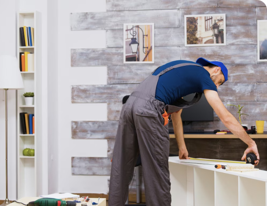 A man performs maintenance on a shelf in a room, ensuring it is secure and functional for storage purposes.