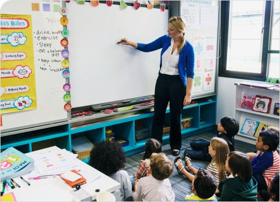 A teacher instructs a group of attentive children in a bright and engaging classroom setting.