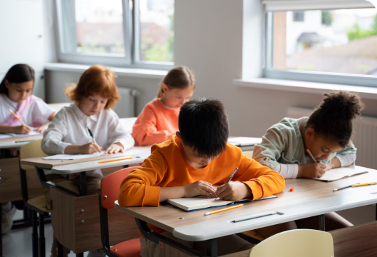 A classroom scene featuring children attentively seated at their desks, engaged in learning activities.