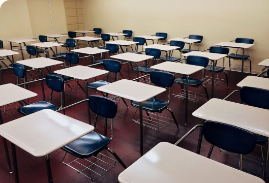 A classroom featuring rows of desks and chairs, showcasing visible maintenance issues that need attention.