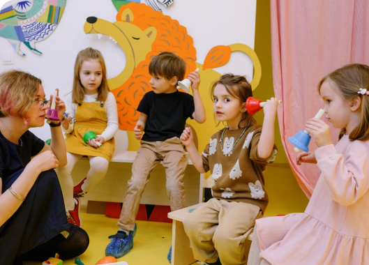 A group of children joyfully playing with various toys in a bright and engaging classroom setting.