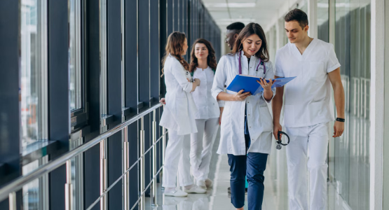 Doctors in a modular hospital building walking through a hallway, prepared for their next patient care duties.