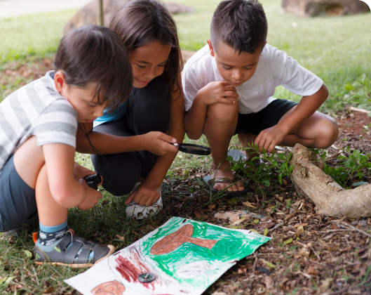 Three children observe a drawing on the ground, engaging with themes of climate change and sustainability in their learning.