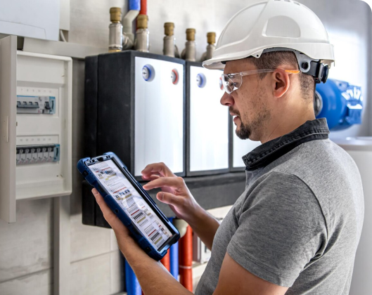 A man in a hard hat and helmet engages with a tablet, representing smart technology at Modular Space.