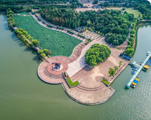 Aerial view of a park featuring a boat on the water, highlighting the importance of water conservation in natural spaces.