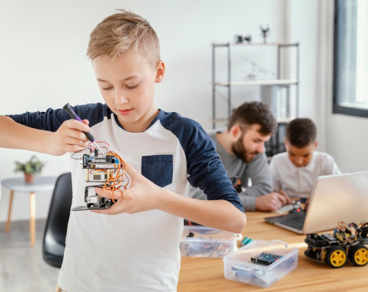 In a classroom, a boy engages in building a robot, demonstrating practical skills and real-world application of engineering concepts.