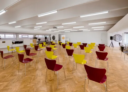 A spacious room featuring a mix of yellow and red chairs, symbolizing a vibrant environment for long-term investment discussions.